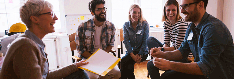 a group of five people of different age groups at a discussion at a office space